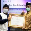 Sekda Kuningan saat menyerahkan penghargaan kepada juara I lomba Pasanggiri Basa Sunda.